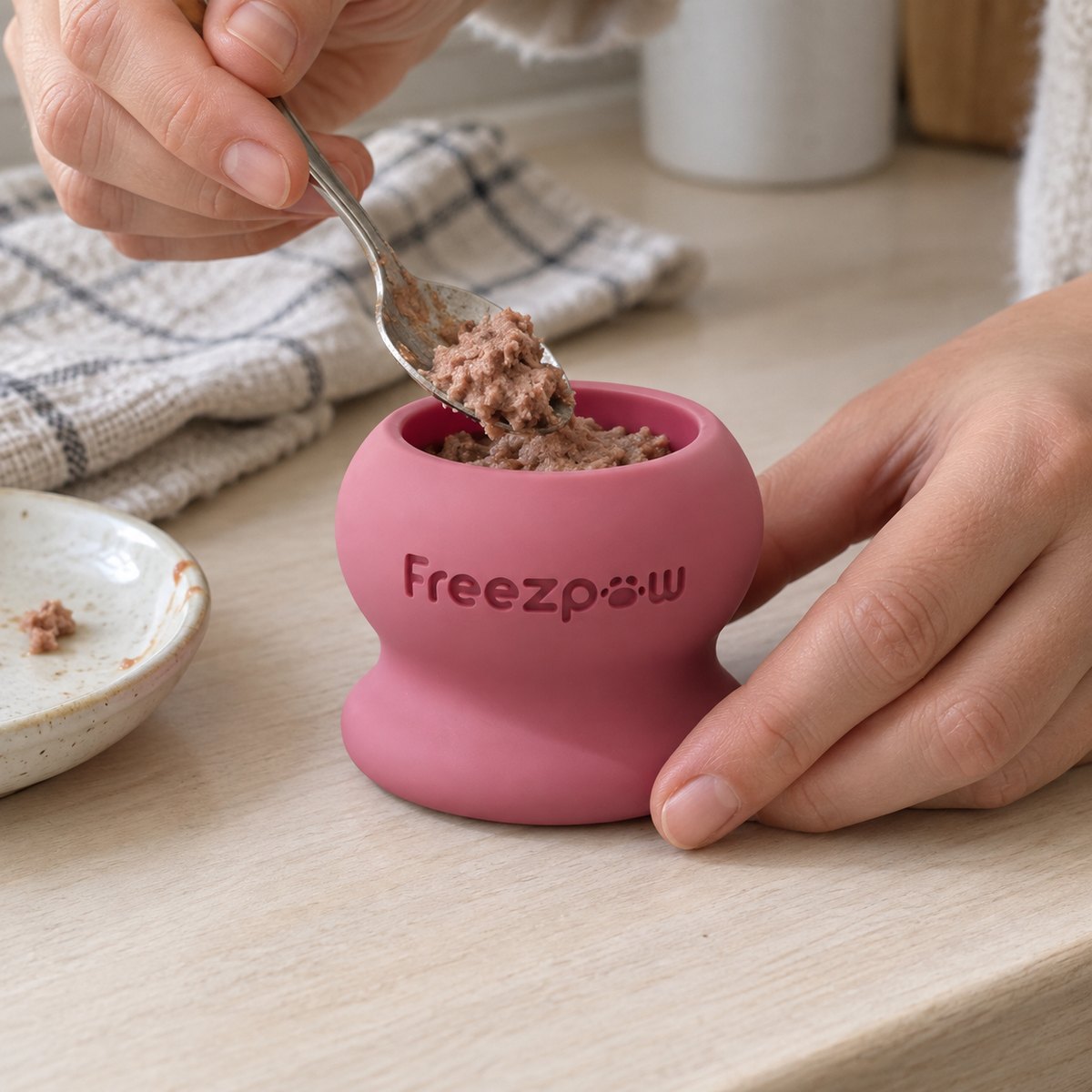 Filling a FreezPounce with a soft treat